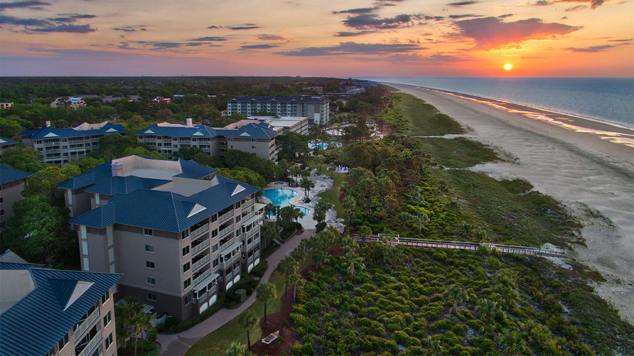 Exterior of Grande Ocean resort timeshare at sunrise showing dunes and beach